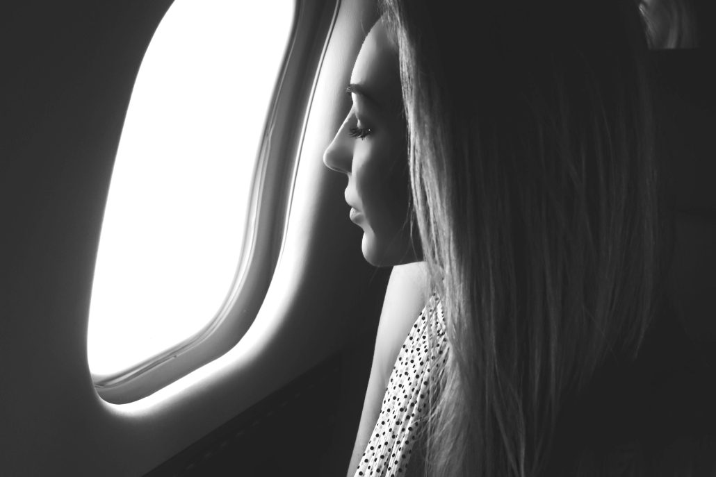 woman looking into the window in a private jet