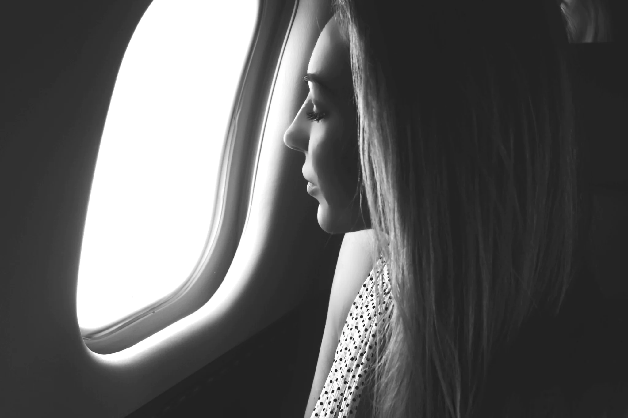 woman looking into the window in a private jet